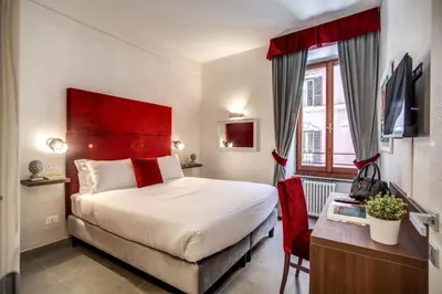 a hotel room with a bed and a red headboard at Tritone Top House in Rome