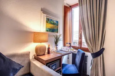 a hotel room with a desk and a window at Tritone Top House in Rome