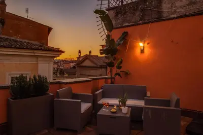 a patio with a table and chairs on a balcony at Tritone Top House in Rome