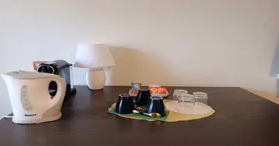 a table with a coffee maker and affeepot and glasses on it at Rome's Best Holidays Guest House in Rome