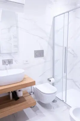 a white bathroom with a toilet and a sink at Stay In Rome in Rome