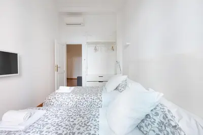 a white bedroom with two beds and a television at Stay In Rome in Rome