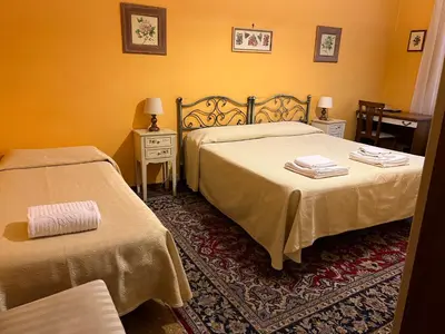 a hotel room with two beds and two tables at B&B San Michele a Porta Pia in Rome
