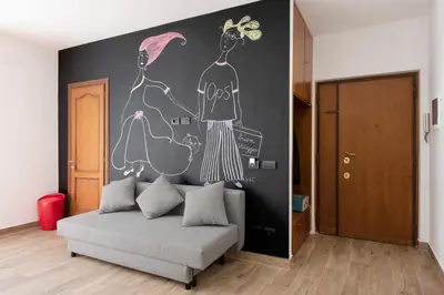 a living room with a couch and a wall with a mural at G&C house in Rome