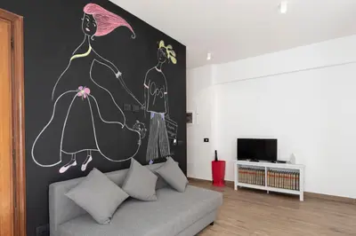 a living room with a couch and a painting on the wall at G&C house in Rome