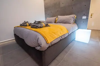 a bedroom with a large bed with a yellow blanket at Cosy studio in the greenest corner of Trastevere in Rome
