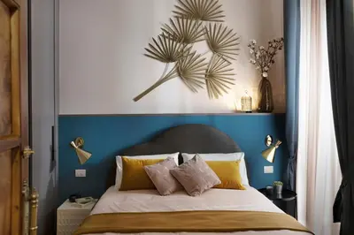 a bedroom with a bed with a blue head board at Luxury Trevi House in Rome