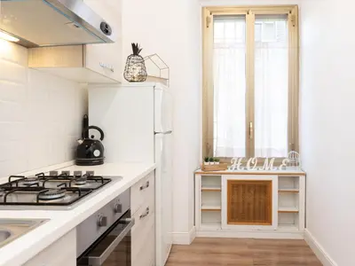 a white kitchen with a stove and a sink at Vatican Apartment Santamaura in Rome