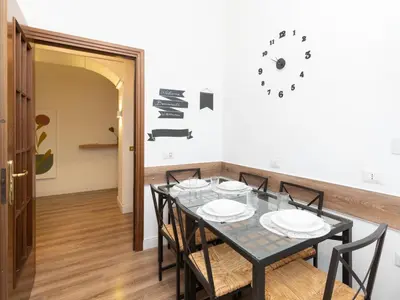 a dining room with a black table and chairs at Vatican Apartment Santamaura in Rome