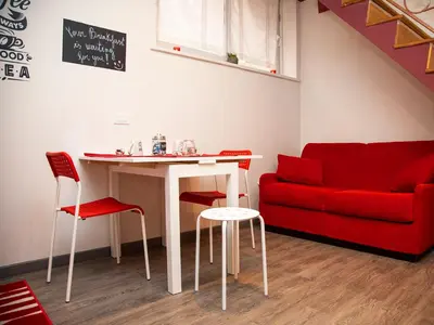 a living room with a table and a red couch at San Pietro apart in Rome
