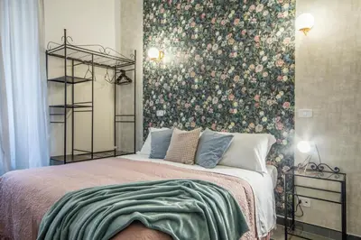 a bedroom with a bed with a floral wallpaper at Appartamento Flora Metro Vittorio in Rome