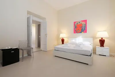 a white bedroom with a bed and two lamps at LC GrandTour Libertà in Rome