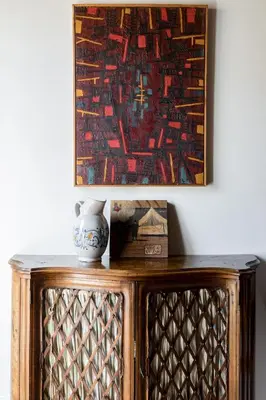 a painting on a wall above a wooden cabinet at Classic and chic apartments in Trastevere in Rome
