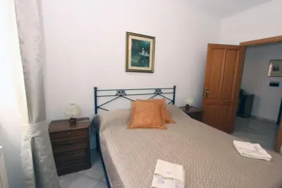 a bedroom with a bed with an orange pillow on it at Torrigio Flat in Rome
