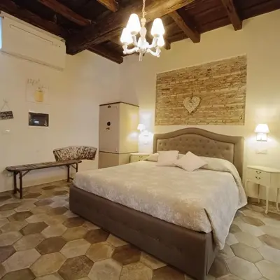 a bedroom with a large bed and a stone wall at Colosseo Sweet Home in Rome