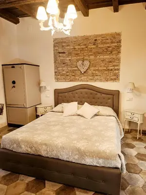 a bedroom with a bed and a brick wall at Colosseo Sweet Home in Rome
