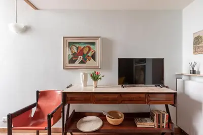a desk with a television and a red chair at iFlat Pantheon Historic Two-Story Apartment in Rome