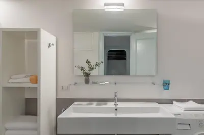 a white bathroom with a sink and a mirror at iFlat Pantheon Historic Two-Story Apartment in Rome