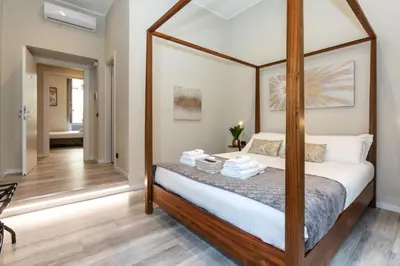 a bedroom with a canopy bed with white sheets at Suites 44 - Guesthouse close to Vaticano, San Pietro, Castel Sant'angelo in Rome