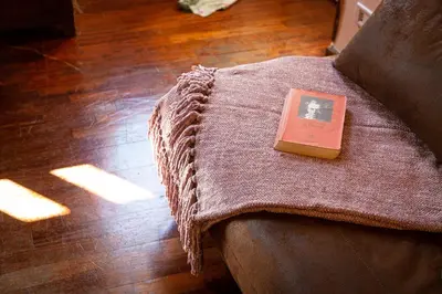a book sitting on top of a couch with a blanket at The Dreamers House in Rome