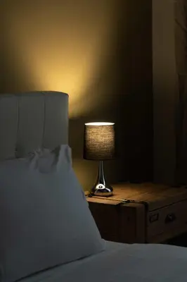 a lamp sitting on a night stand next to a bed at Corso 101 in Rome