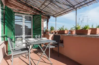 a table and chairs on the balcony of a house at GuestHost - Piazza Navona Panoramic Penthouse in Rome