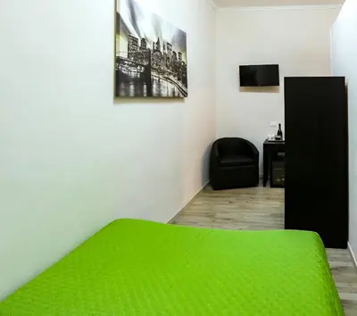 a bedroom with a green bed and a black chair at Lydka Domus in Rome