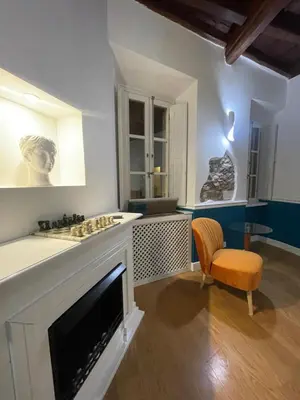 a living room with a fireplace and a chair at Boutique Apartment Pantheon in Rome