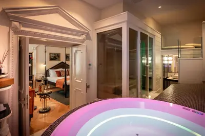 a bathroom with a tub and a bedroom at Torre Argentina Relais - Residenze di Charme in Rome