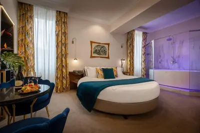 a hotel room with a large bed and a table at Torre Argentina Relais - Residenze di Charme in Rome