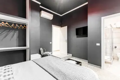 a bedroom with black walls and a bed and a tv at Benincasa Bed&Breakfast in Rome