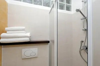 a bathroom with a shower and some towels at Elegant 3-Bed Apartment 10' Termini Wi-Fi AC in Rome