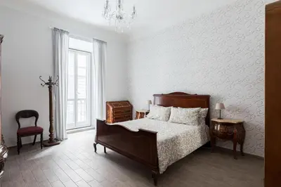 a bedroom with a bed and a chandelier at Nobile Casa St.Maria in Rome