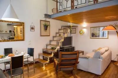 a living room with a white couch and a staircase at Loft in Testaccio in Rome