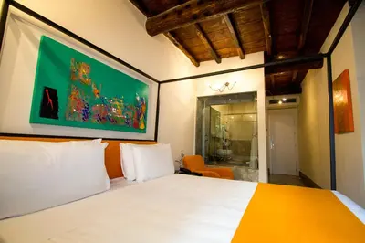 a bedroom with a white bed and a painting on the wall at Argileto Terra in Rome