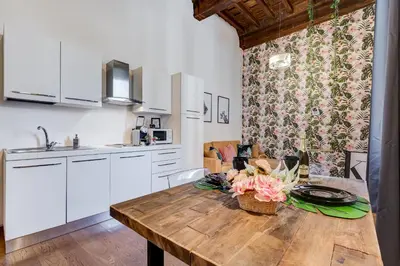a kitchen with a wooden table with flowers on it at Klioos Apartment in Rome