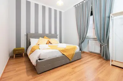 a bedroom with a bed with a striped wall at Relais Mantellini in Rome