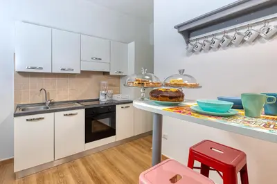 a kitchen with white cabinets and a counter with food on it at Relais Mantellini in Rome