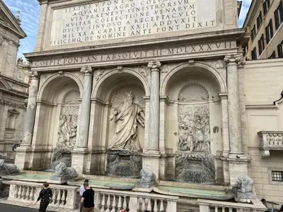 a building with a statue on the side of it at Center House Colosseo in Rome