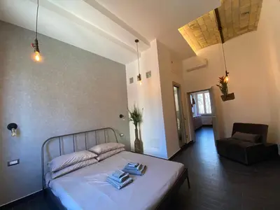 a bedroom with a bed and a chair at Basilica Papale di San Paolo Appartamento Moderno - YOURhOME in Rome