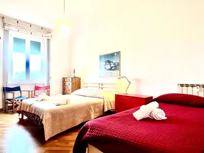 a bedroom with two beds and a red blanket at Casa Pinturicchio in Rome