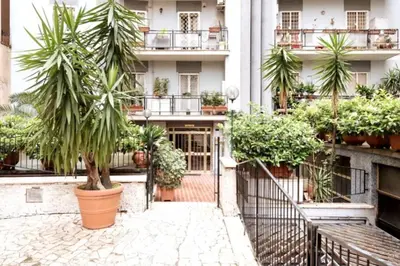 a courtyard of a building with palm trees and plants at RomeEyes apartment in Rome