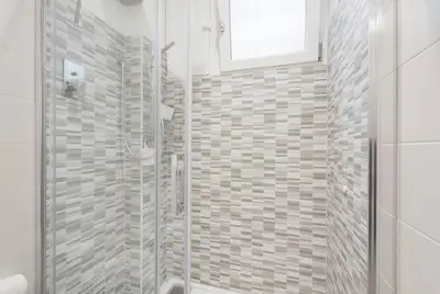 a white bathroom with a shower and a window at RomeEyes apartment in Rome