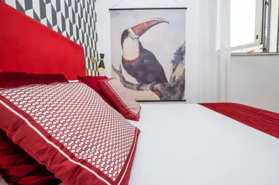 a bedroom with a red bed with a bird picture on the wall at The Vista Rooms & Terrace in Rome