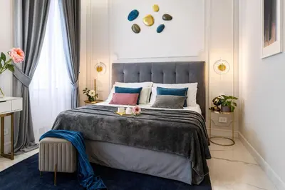 a bedroom with a large bed with a blue rug at Rome Deluxe Apartments in Rome