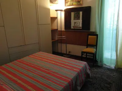 a bedroom with a bed and a lamp and a chair at Abitazione Pigneto B&B in Rome