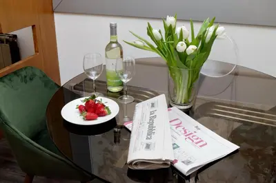 a table with a plate of strawberries and a bottle of wine at Urbana Delicious Flat in Rome