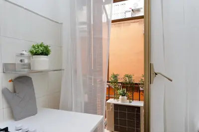 a bathroom with a shower curtain and a window at Urbana Delicious Flat in Rome