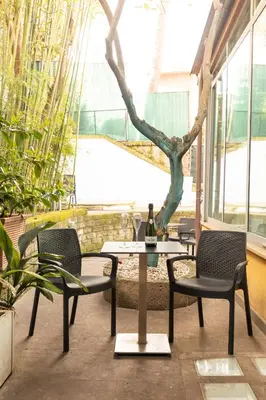 a table with two chairs and a bottle of wine at Relais Clivo Vaticano in Rome