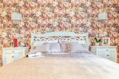 a bedroom with a bed with a floral wallpaper at Luxury Stars In Rome - Andromeda apartment in Colosseum in Rome
